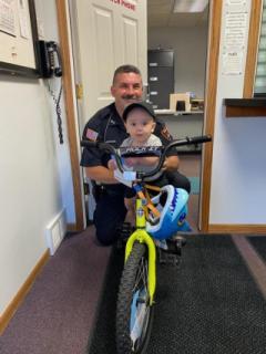 Officer McElroy handing out a bike from our annual Fair bike drawing